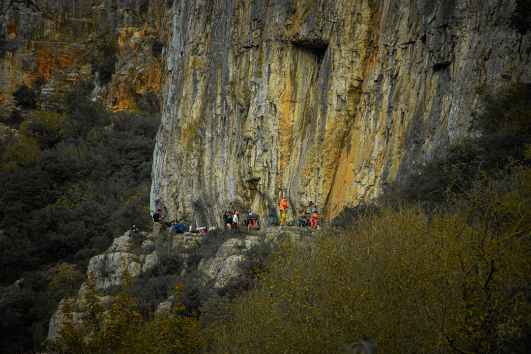 Climbers gathered at the base of a large rock face.
